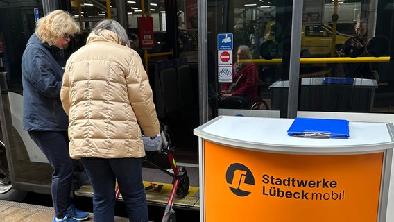 Eine ältere Frau lernt, mit einem Gehwagen in den Bus einzusteigen. Eine ältere Frau lernt, mit einem Gehwagen in den Bus einzusteigen. © Stadtwerke Lübeck