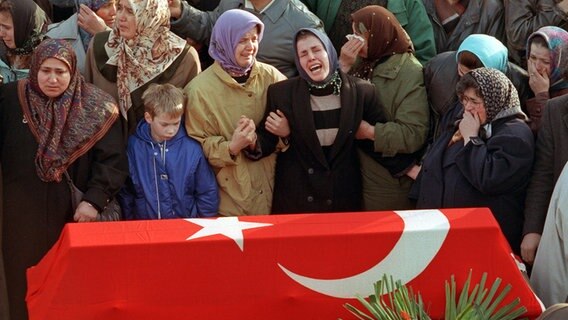 Trauernde Türkinnen hinter einem Sarg bei der Trauerfeier für die Opfer des Möllner Anschlags am 27.11.1992 in Hamburg. © picture alliance/dpa-Bildarchiv Foto: DB Hesse