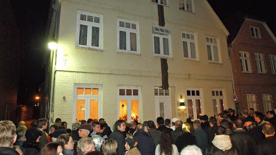 15 Jahre nach dem Brandanschlag in Mölln gedenken zahlreiche Menschen vor dem Brandhaus in der Mühlenstraße der Opfer. © picture alliance/dpa Foto: Wolfgang Langenstrassen