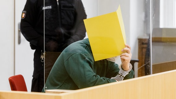 Ein Angeklagter im Gericht verbirgt sein Gesicht © Markus Scholz/dpa Foto: Markus Scholz/dpa