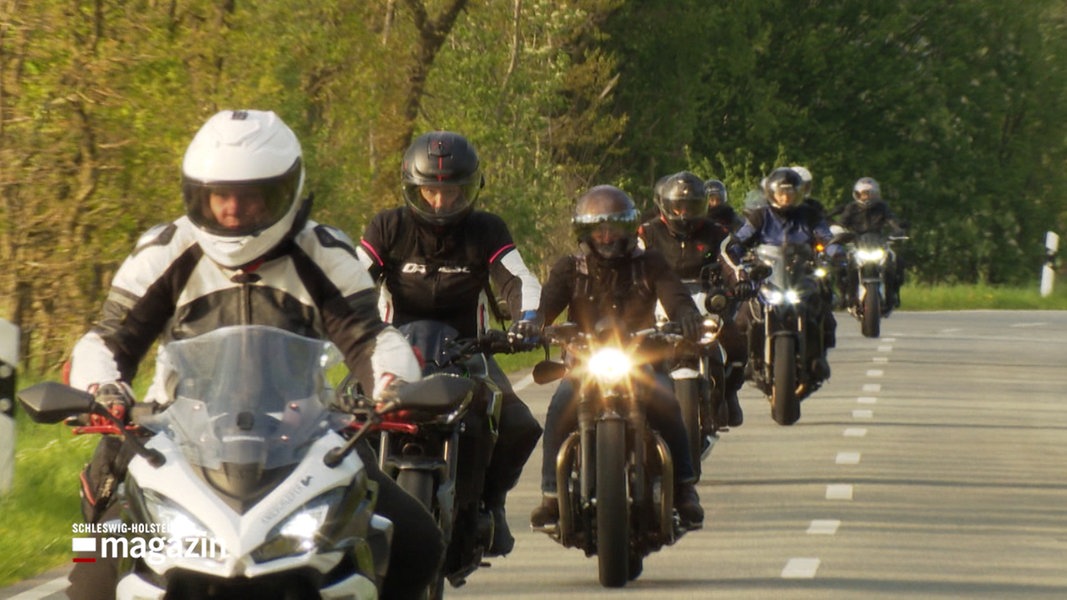 Eine Gruppe von Motorradfahrerinnen fährt über eine Straße.