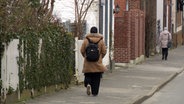 Eine Frau mit Kopftuch geht eine Straßen entlang. © NDR 