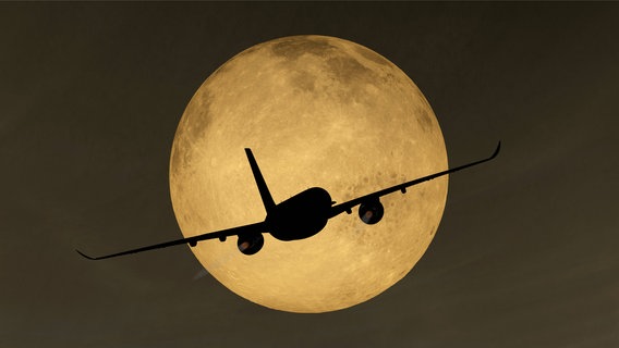 Die Silhouette eines Flugzeugs vor einem Vollmond. © Imago Images / IlluPics Foto: Imago Images / IlluPics