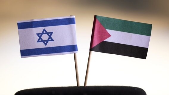 Die israelische Flagge und die palästinensische Flagge stehen auf einem Tisch. © picture alliance | Panama Pictures Foto: Dwi Anoraganingrum