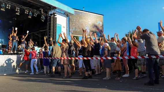 Menschen machen Kniebeugen vor der NDR Bühne in Schenefeld. © NDR Foto: Tobias Senff