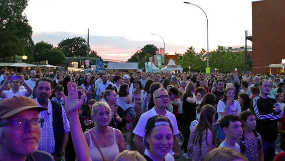 Menschen feiern vor der NDR Bühne in Schenefeld bei Dämmerung. © NDR Foto: Tobias Senff