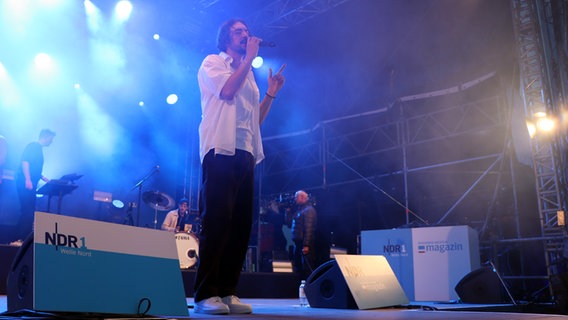 Ein Sänger performt auf der NDR Bühne in Schenefeld bei Dämmerung. © NDR Foto: Tobias Senff