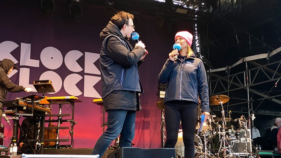 Die NDR-Moderatoren Horst Hoof und Kristin Recke vom NDR Fernsehen stehen beim NDR Festivals auf der Watttribüne in Büsum © NDR Foto: Torsten Creutzburg