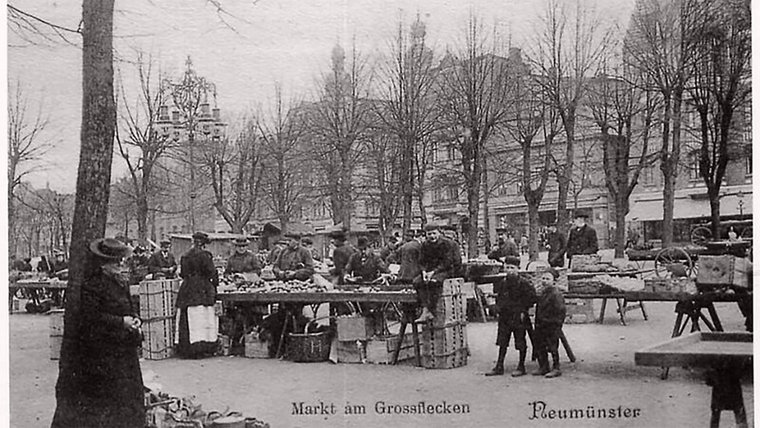 Eine historische Grafik des Großflecken in Neumünster. Auf dem Platz tummeln sich viele Marktbesucher © Archiv Alfred Heggen