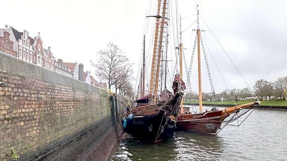 Ein an der Kaimauer in Lübeck festgemachtes Schiff liegt schief im Niedrigwasser. © NDR Foto: Balthasar Hümbs