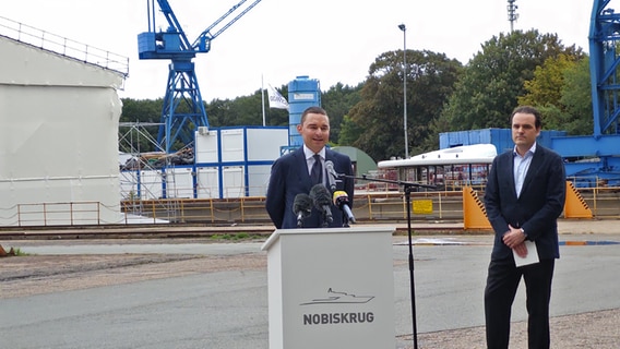Investor Lars Windhorst spricht auf dem Geländer von Nobiskrug vor Mitarbeitenden. © NDR Foto: Peer-Axel Kroeske