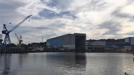 Das Dockgebäude der Werft Nobiskrug in Rendsburg steht vor leicht bewölktem Himmel. © NDR Foto: Arne Helms