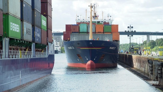 Ein großes Containerschiff hat in der Schleuse in Brunsbüttel festgemacht. © NDR Foto: NDR Screenshot
