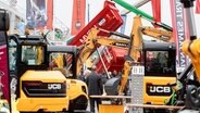 Baumaschinen sind im Außenbereich der Messe NordBau ausgestellt © DPA Foto: Markus Scholz