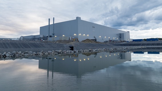 Eine Fabrikhalle steht in der Nähe einer Wasserfläche. © Northvolt Foto: Northvolt