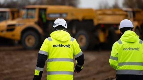 Northvolt-Mitarbeiter stehen auf einer Baustelle.  © dpa Foto: Frank Molter