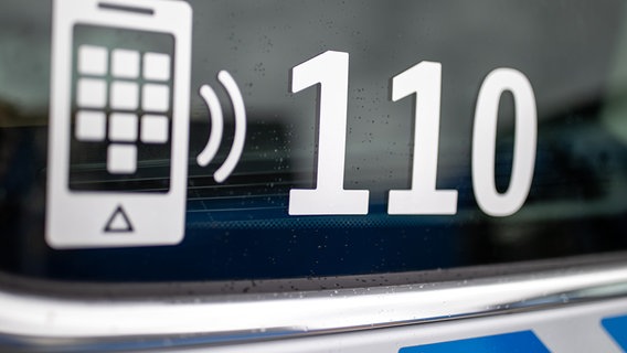 Der Nummer des Polizeinotrufs 110 steht auf der Scheibe eines Polizeifahrzeugs. © picture alliance/dpa Foto: Daniel Karmann