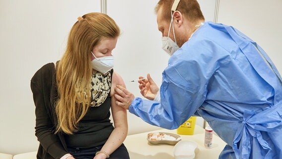 Prisdorf: R. Scharp (r), Gesundheits-und Krankenpfleger, verimpft in einem Impfzentrum einer Frau den Impfstoff Nuvaxovid des Pharmaunternehmens Novavax. © dpa-Bildfunk Foto: Georg Wendt/dpa