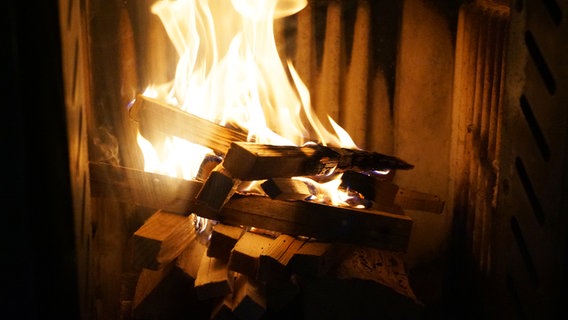 Sorgfältig gestapeltes Holz verbrennt in einem Kaminofen. © NDR Foto: Mirja Pape