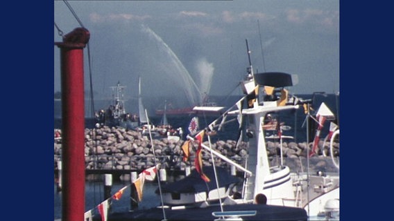 Ein Feuerwehrschiff dpritzt mit Wasser in der Kieler Förde. © ARD 