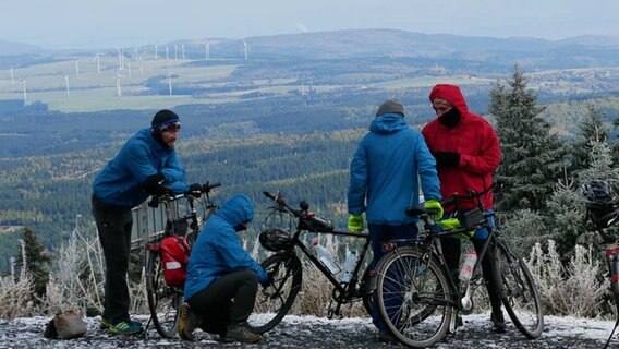 Vier Männer stehen mit Fahrrädern in der Natur und sind einander zugewandt.  Foto: Projekt Open Eyes