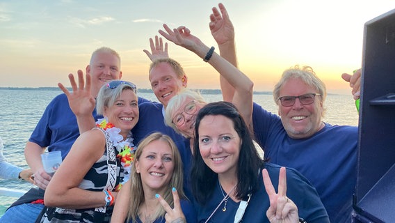 Menschen feiern ausgelassen auf einem Schiff und posieren für die Kamera © NDR Foto: Andrea Schmidt