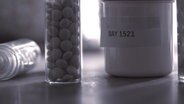 Drei kleine Behälter mit Medikamenten. © NDR 