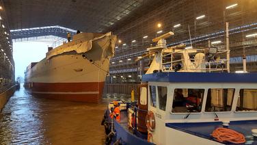 Die "Peking" wird ins Trockendock manövriert. Die "Peking" wird ins Trockendock manövriert. © NDR Foto: Carsten Salzwedel