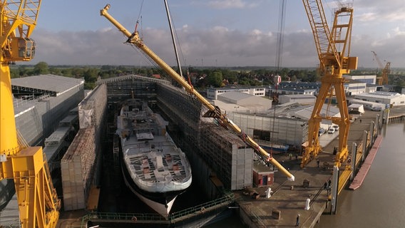 Ein Mast wird auf ein Schiff gesetzt. © NDR 