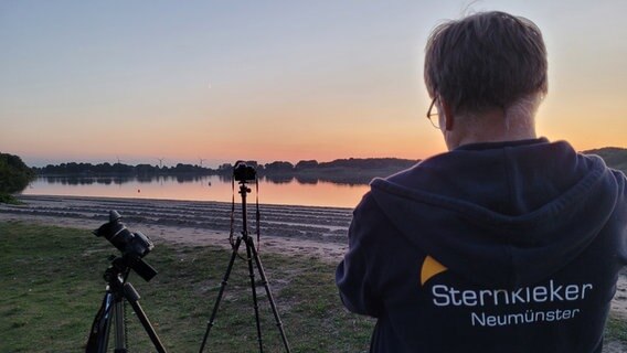 Ein Mann hat sich mit Kameras an einem See aufgestellt um Sterne zu fotografieren.  Foto: Kai Peukert