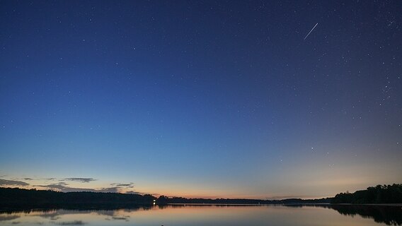 Ein Sternenhimmel ist zu sehen mit einer Sternenschnuppe.  Foto: Rainer Reimer aus Neumünster
