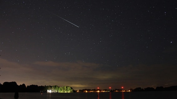 Eine Sternschnuppe fliegt über den Einfelder See. © Sternwarte Neumünster Foto: Marco Ludwig