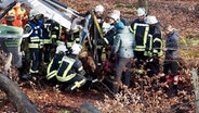 Einsatzkräfte der Feuerwehr in einem Wald © NDR Foto: NDR Screenshot