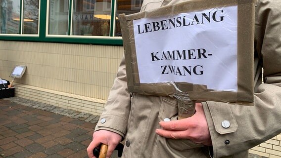 Selbst gebasteltes Schild mit der Aufschrift "Lebenslang Kammerzwang" © NDR Foto: Carsten Janz