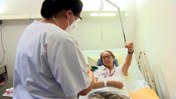 Eine Pflegerin macht sich bereit bei einer Patientin im St. Elisabeth Krankenhaus in Eutin den Blutdruck zu messen. © NDR 