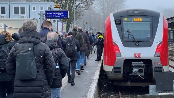 Viele Menschen stehen an einem Bahnhof neben einem haltenden Zug. © NDR Foto: Tobias Senff