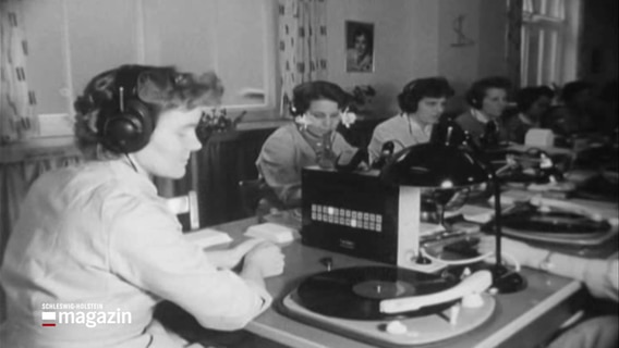 Frauen sitzen an einem Tisch und kontrollieren Schallplatten auf Fehler. © NDR 