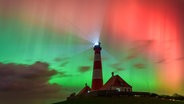 Am Himmel leuchten bunte Polarlichter und Lichter des Leuchtturms Westerheversand. © Mike Mohr Foto: Mike Mohr