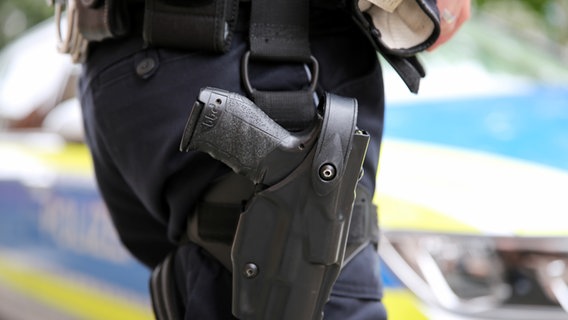Eine Dienstwaffe hängt geschlossen im Halfter am Gürtel eines Polizisten. © NDR Foto: Pavel Stoyan