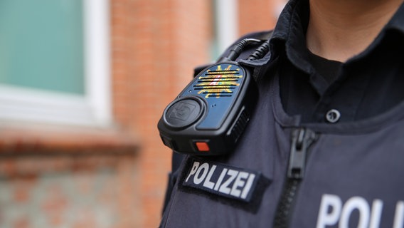 Ein Funkgerät hängt an der Uniform eines Polizisten. © NDR Foto: Pavel Stoyan