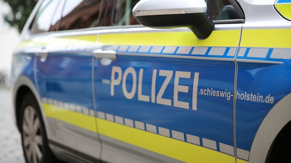 Schriftzug "www.POLIZEIE.schleswig-holstein.de" steht an der Tür eines Streifenwagens der Polizei. © NDR Foto: Pavel Stoyan