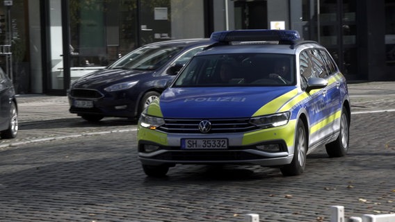 Ein Streifenwagen der Polizei fährt auf einer Straße in der Innenstadt von Neumünster. © NDR 