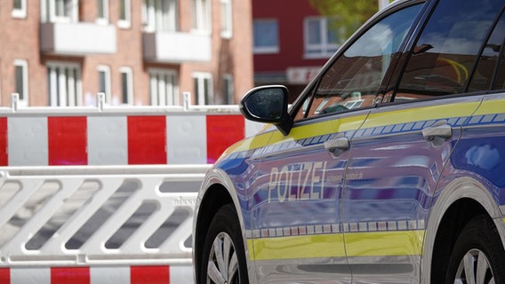 Ein Polizeifahrzeug steht vor einer Absperrung. © NDR Foto: Carsten Salzwedel