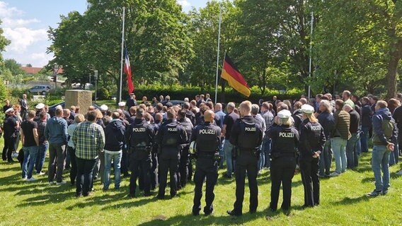 Polizeibeamte und Mitglieder der GdP (Gewerkschaft der Polizei) sind von hinten zu sehen, wie sie in Trauer eine Schweigeminute einlegen. © Jannik Wölffel Foto: Jannik Wölffel
