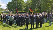 Polizeibeamte und Mitglieder der GdP (Gewerkschaft der Polizei) sind von hinten zu sehen, wie sie in Trauer eine Schweigeminute einlegen. © Jannik Wölffel Foto: Jannik Wölffel