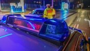 Die Polizei kontrolliert einen Autofahrer. © IMAGO / onw-images 