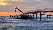 Ein 20 mal 50 Meter großer, schwimmender Ponton samt Kran hat sich bei Wellengang unter der Seebrücke in Timmendorfer Strand verkeilt © NDR Foto: Julian Marxen