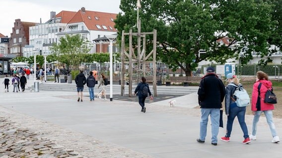 Menschen laufen entlang der neuen Trave-Promenade. © dpa-Bildfunk Foto: Markus Scholz