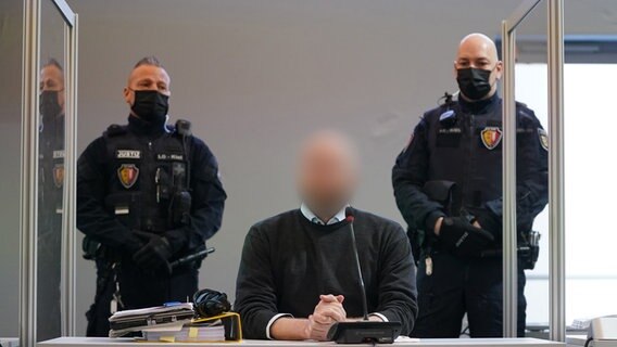 Ein Angeklagter sitzt zu Beginn des Prozesses wegen eines Dreifachmordes im Sitzungssaal. © Marcus Brandt/dpa Foto: Marcus Brandt/dpa