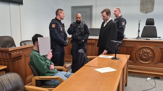 Der Angeklagte Fisnik H sitzt im Landgericht Kiel im Prozess wegen Mordes an einem Mann auf einer Parkbank im Juni 2022 © NDR Foto: Cassandra Jane Arden
